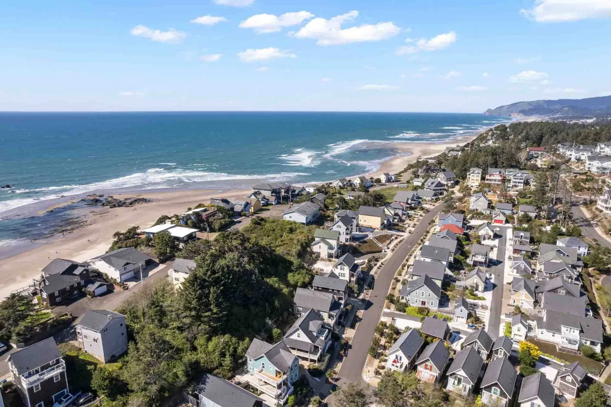 A sweeping coastal landscape features neighborhood houses, a winding road, and scenic ocean views. The scene captures the essence of beachside living, with opportunities for walks, community gatherings, and enjoying the sunset.