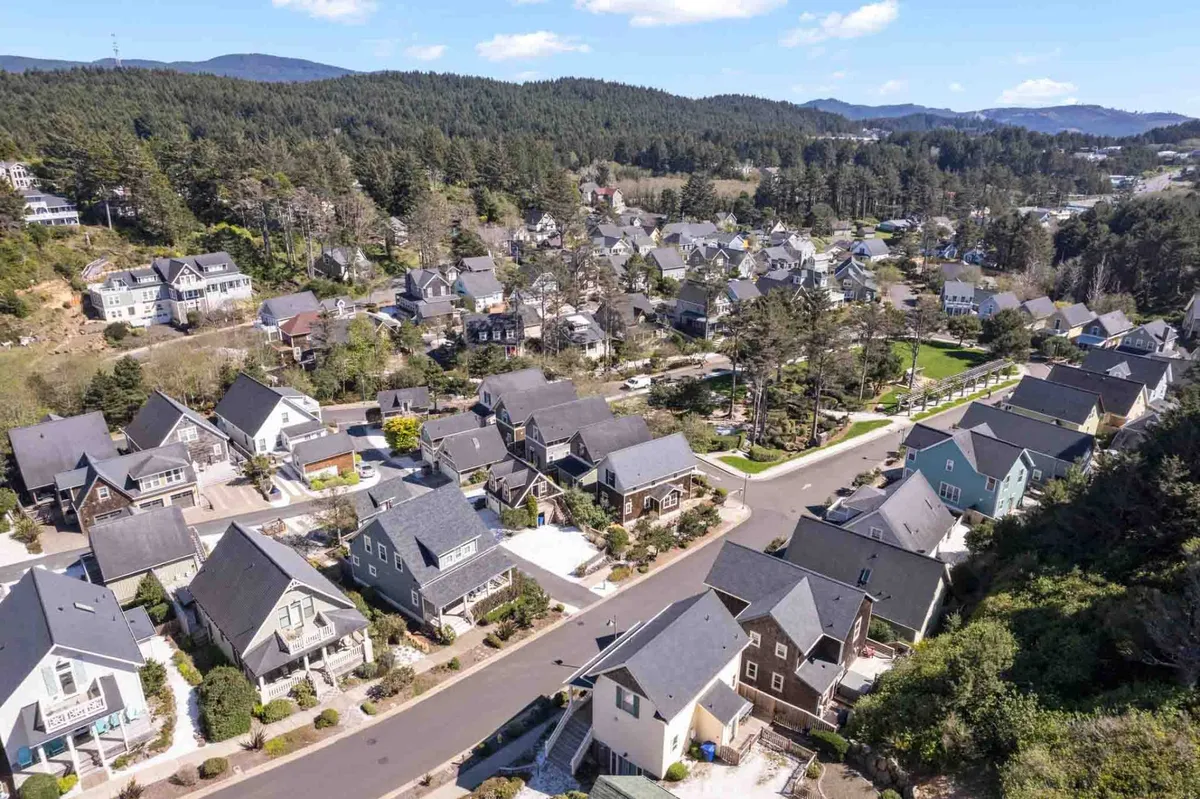 A peaceful street scene in Olivia Beach, with residential homes nestled among grassy spaces and winding lanes. The greenery and open layout encourage walking, biking, and safe exploration for families and children.